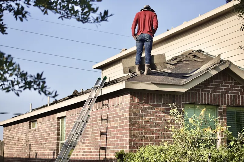 Professional roofer working on a residential roof in Saintsville